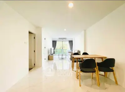 Spacious modern living room with dining area and large windows offering natural light.
