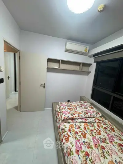 Cozy bedroom with floral bedding and air conditioning in modern apartment