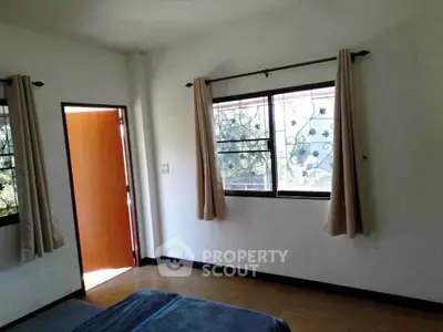 Spacious bedroom with large windows and natural light, perfect for a cozy and inviting atmosphere.