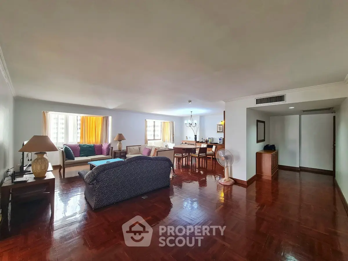 Spacious living room with polished wooden floors and cozy seating area