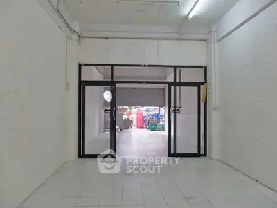 Spacious commercial space with glass doors and tiled flooring, ideal for retail or office use.