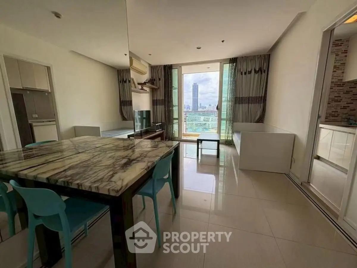 Spacious living room with marble dining table and city view in modern apartment.