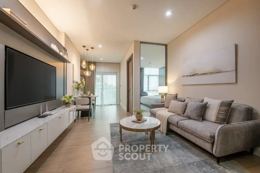 Modern living room with elegant decor and spacious layout, featuring a large TV and stylish furniture.
