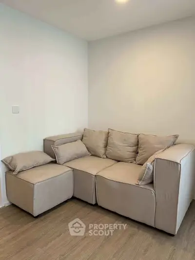 Cozy beige sectional sofa in a modern living room with wooden flooring.