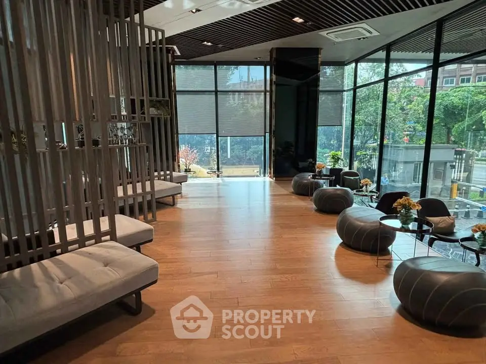 Modern lobby with stylish seating and large windows offering a view of lush greenery.