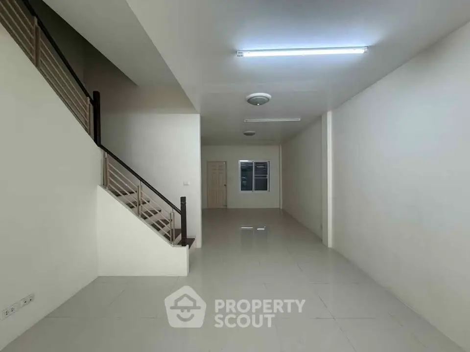 Spacious open-plan living area with staircase and modern lighting