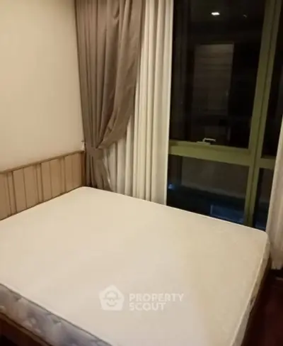 Cozy bedroom with large window and elegant curtains, perfect for relaxation and comfort.