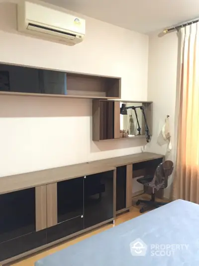 Modern bedroom with built-in wooden furniture and air conditioning