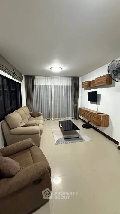 Spacious living room with modern furniture and large window for natural light.