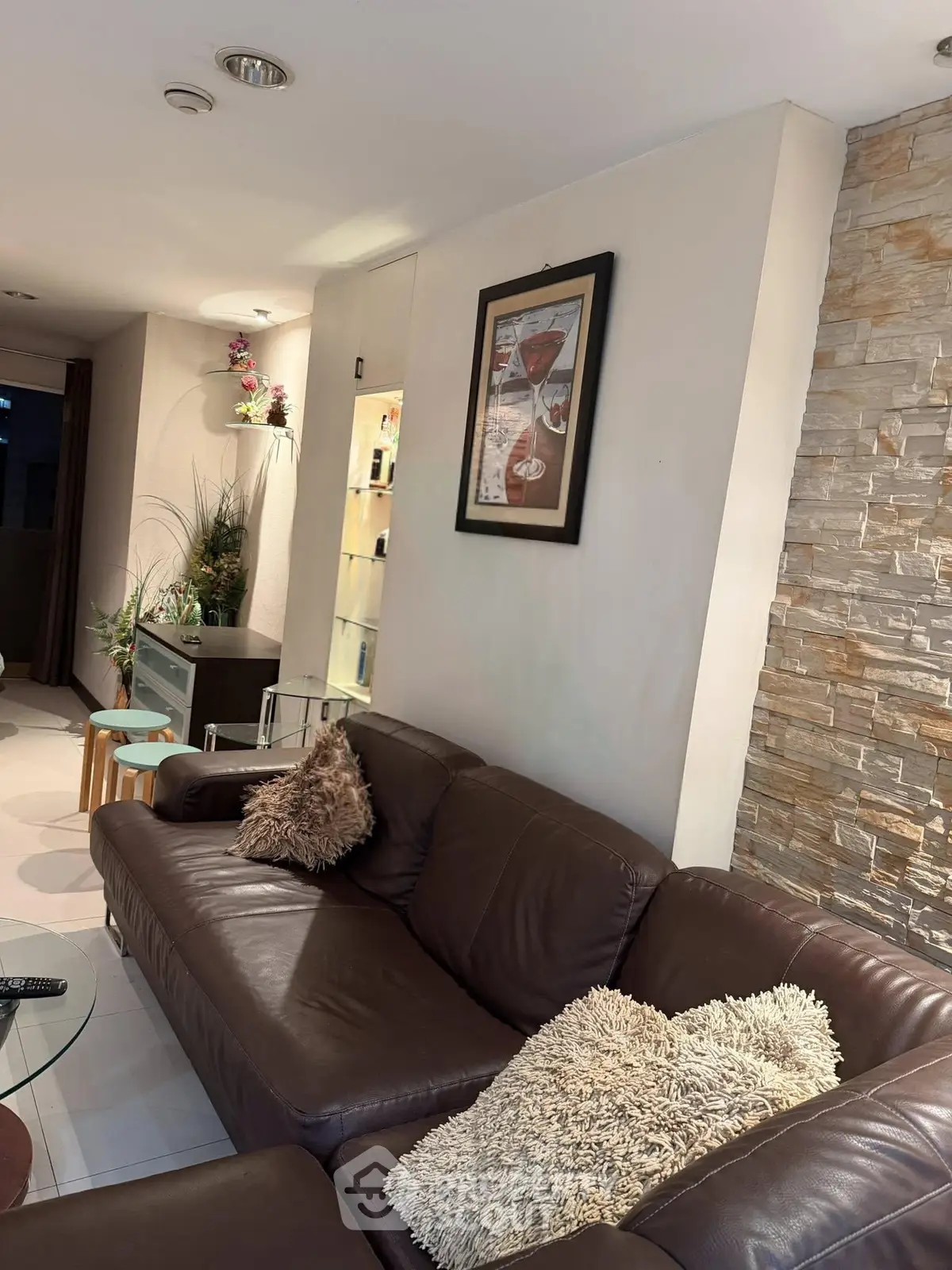 Stylish living room with leather sofa and decorative stone wall, perfect for modern comfort.