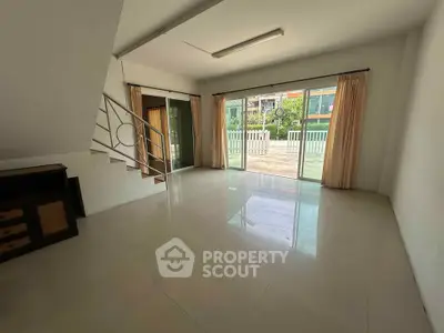 Spacious living room with large windows and garden view, perfect for family gatherings.