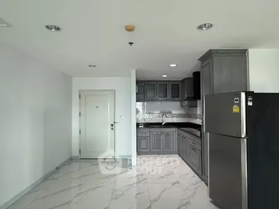 Modern kitchen with sleek gray cabinets and stainless steel appliances in a spacious apartment.