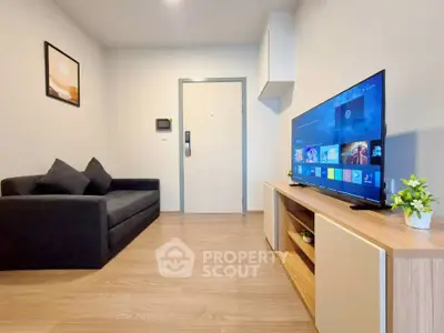 Modern living room with sleek furniture and large TV, perfect for relaxation and entertainment.