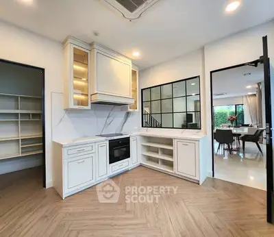 Modern kitchen with sleek design and open layout, featuring built-in oven and elegant cabinetry.