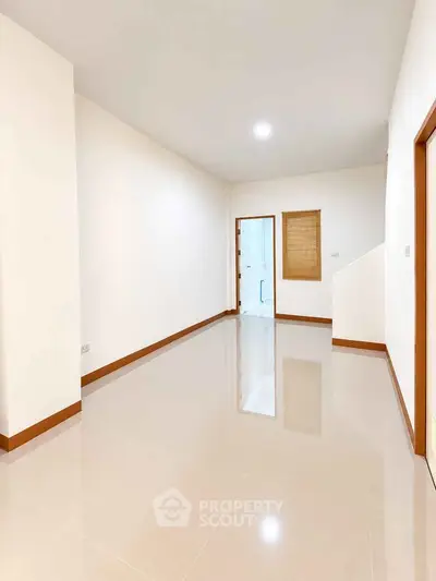 Spacious empty room with glossy tiled floor and bright lighting, ideal for customization.