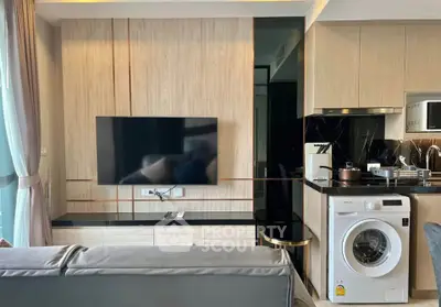 Modern living room with sleek TV setup and integrated washing machine in stylish apartment.