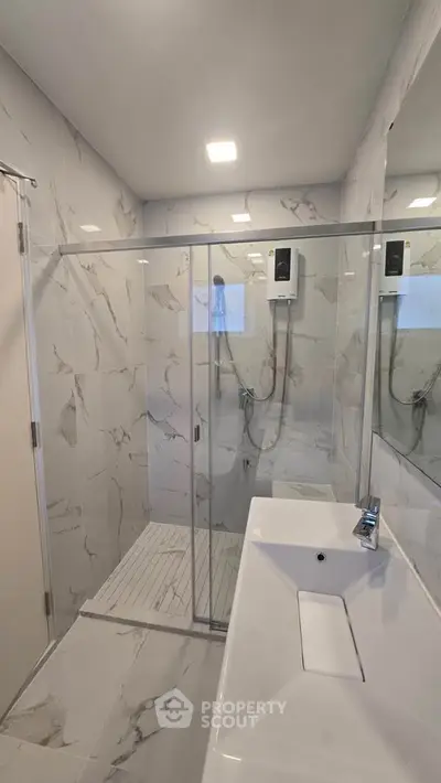 Modern bathroom with glass shower and sleek white fixtures
