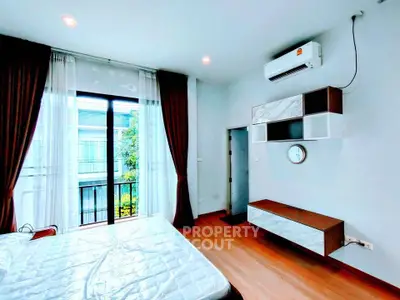 Modern bedroom with large window and air conditioning in a stylish apartment.