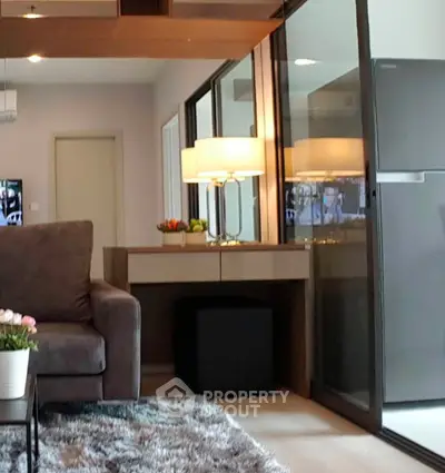 Modern living room with plush sofa, stylish decor, and large glass doors leading to balcony.
