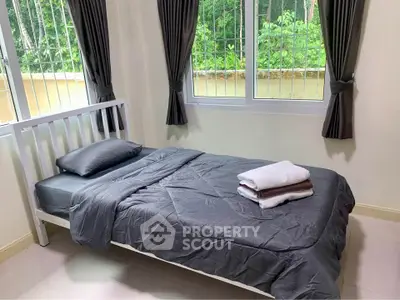 Cozy bedroom with single bed and garden view, perfect for relaxation.