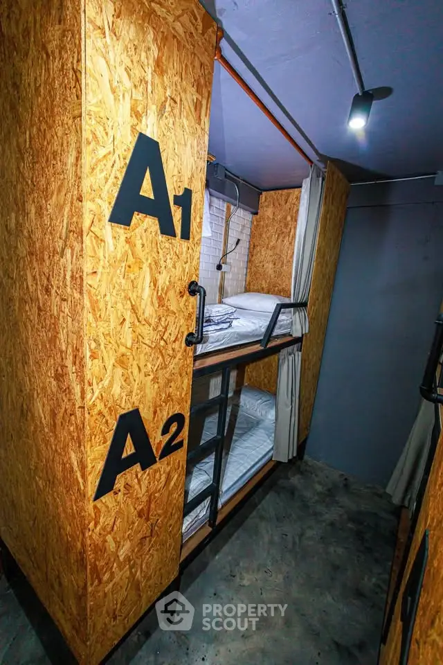 Compact and modern capsule-style sleeping pods with cozy bedding in a shared living space.