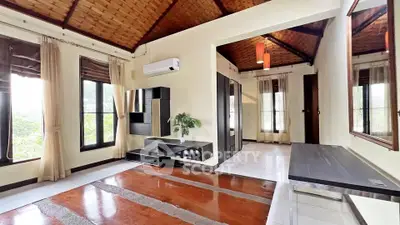 Spacious living room with wooden ceiling and modern decor in a serene setting.