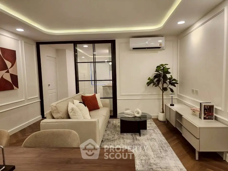 Modern living room with stylish decor, featuring a cozy sofa, elegant lighting, and a sleek air conditioning unit.