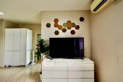 Modern living room with TV, air conditioning, and stylish decor in a cozy apartment.