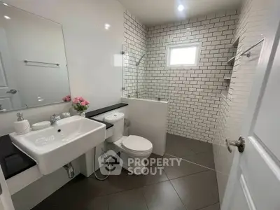 Modern bathroom with sleek design, featuring white subway tiles and contemporary fixtures.