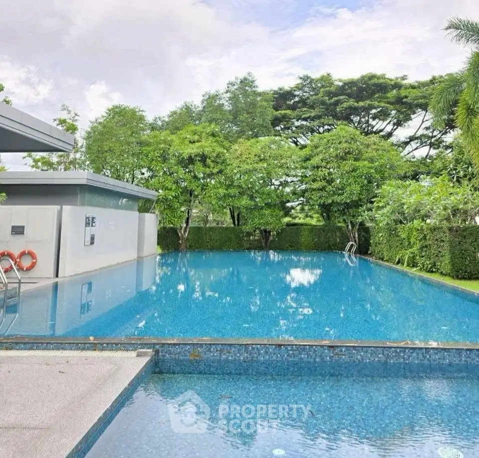 Luxurious outdoor swimming pool surrounded by lush greenery in a serene residential setting.