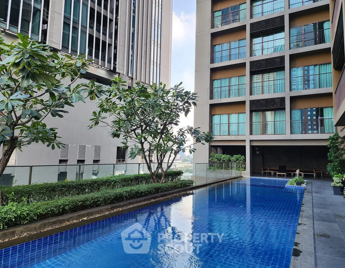 Luxurious high-rise apartment with stunning pool and lush greenery, perfect for urban living.