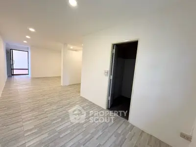 Spacious modern interior with sleek flooring and bright lighting, ideal for versatile living or office space.