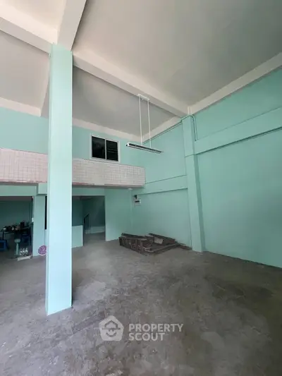 Spacious industrial-style interior with high ceilings and mezzanine level.