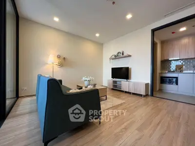 Modern living room with sleek furniture and open kitchen layout, perfect for contemporary living.