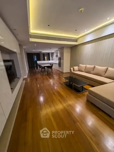 Spacious modern living room with elegant wooden flooring and stylish furniture
