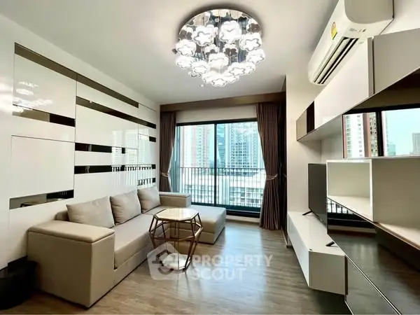 Modern living room with stylish chandelier and large windows offering city views.