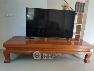 Spacious living room with elegant wooden table and modern flat-screen TV
