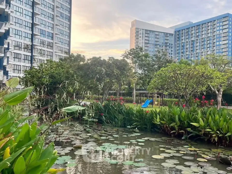 Scenic view of modern apartment buildings with lush garden and pond