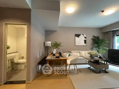 Modern living room with elegant decor and open view to a stylish bathroom, featuring cozy seating and natural light.