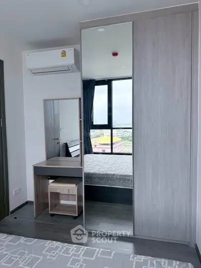 Modern bedroom with mirrored wardrobe and air conditioning in a high-rise apartment.