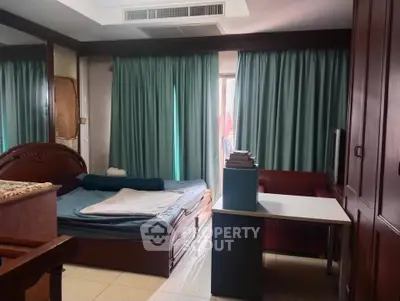 Cozy bedroom with natural light, featuring a bed, desk, and wardrobe, ideal for comfortable living.
