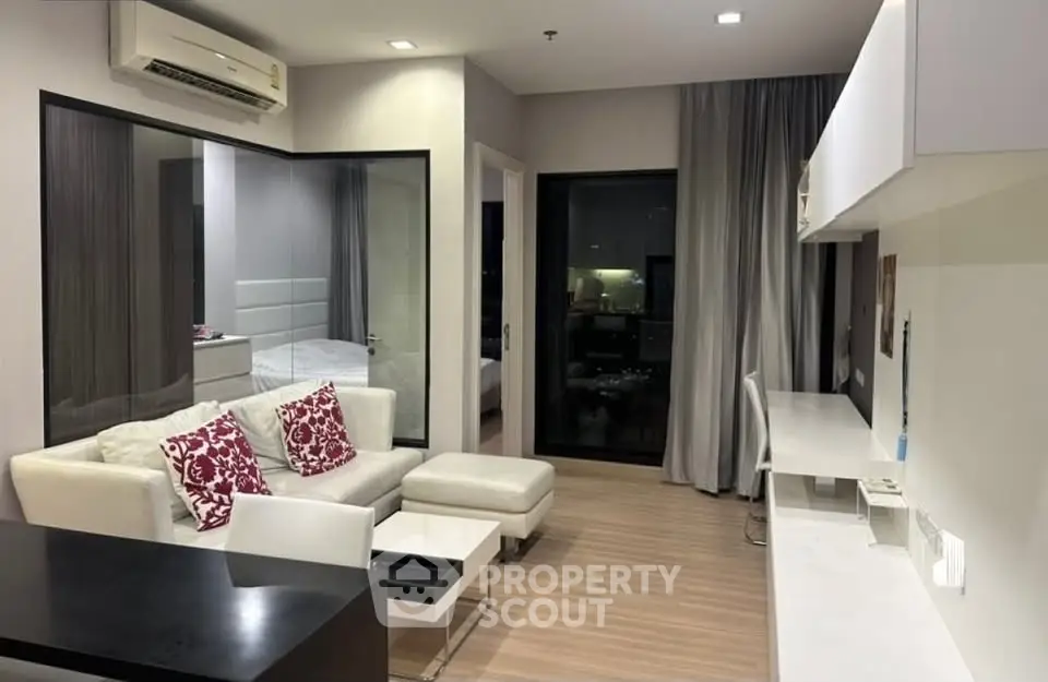 Modern living room with stylish decor and open layout, featuring a cozy sofa and sleek workspace.