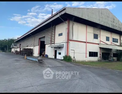 Spacious industrial warehouse with large loading dock and ample outdoor space, ideal for logistics and storage.