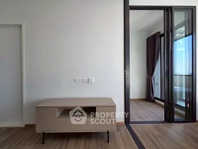 Modern minimalist interior with wooden flooring and open balcony access
