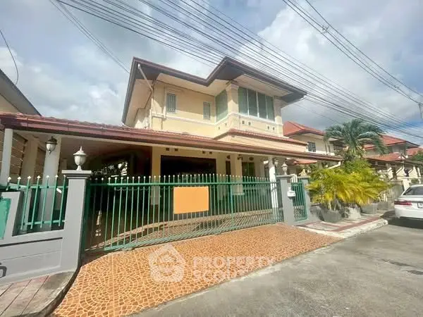 Charming two-story house with gated entrance and spacious driveway in a serene neighborhood.