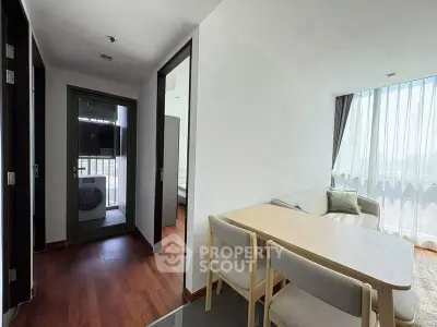 Modern apartment interior with cozy living room and dining area, featuring large windows and wooden flooring.