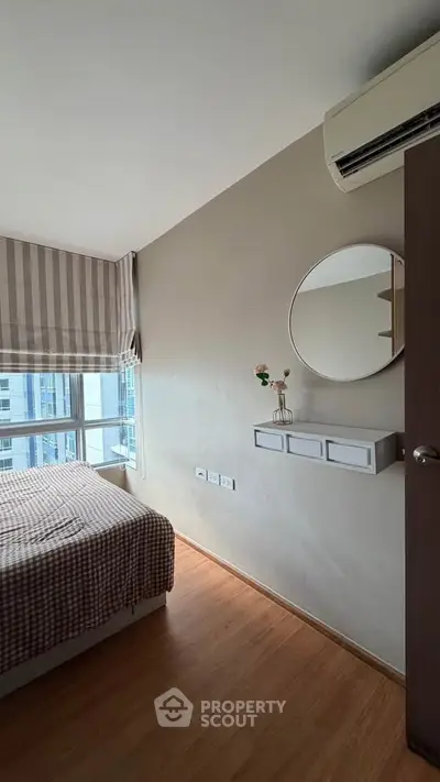 Cozy bedroom with modern decor and large window offering city views, featuring a stylish air conditioner and wall-mounted shelf.
