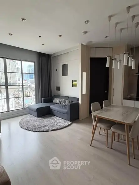 Modern living room with stylish furniture and large window offering city views