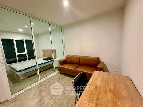 Modern apartment with glass partition, cozy living area, and stylish furnishings.