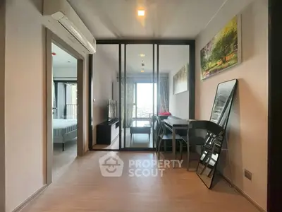 Modern apartment interior with open layout, featuring a dining area and bedroom view.